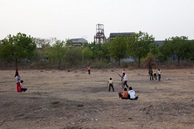 Children play cricket within the grounds of the abandoned factory